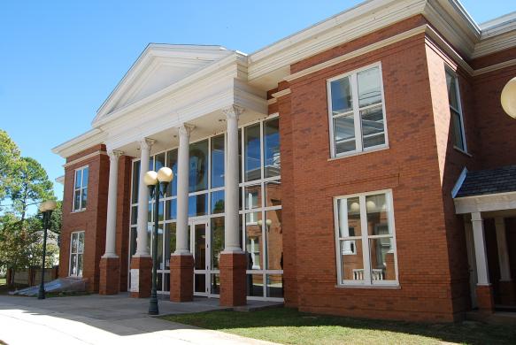 A hand holding an official seal or certificate in a courthouse office.